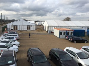 Blick auf den Parkplatz für die Mitarbeiter und einige Zelte.