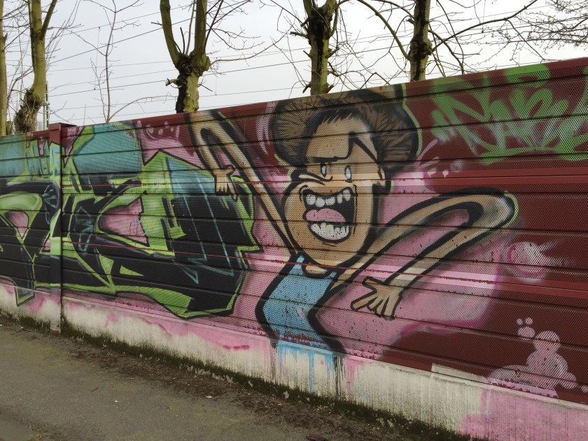 In der Bleiberger Straße gesehen (wenn ich mich richtig erinnere). Dargestellt ist eine Bloggerin, die sich über nicht-öffentliche Beratungen aufregt. ;-))